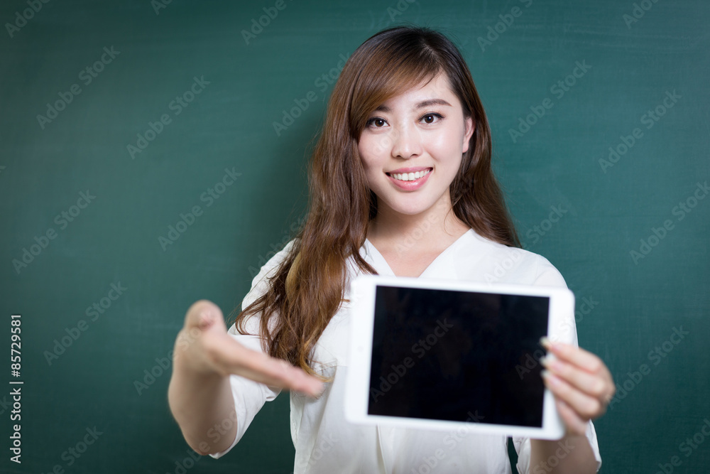 asian beautiful woman holding tablet in front of blackboard