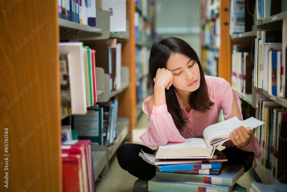 Asian women Sitting in the library A dazed expression showed a lack of understanding about the book 