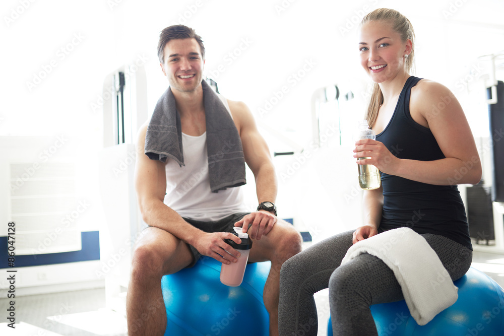 Active Young Couple In the Gym Smiling at Camera