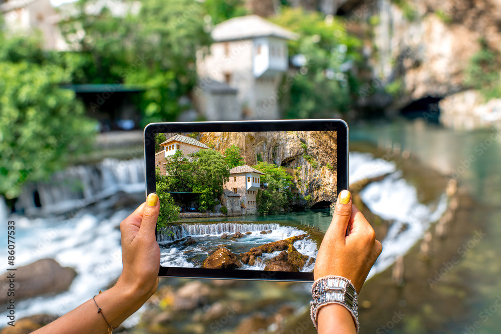 Woman photographing house on Buna spring in Blagaj village