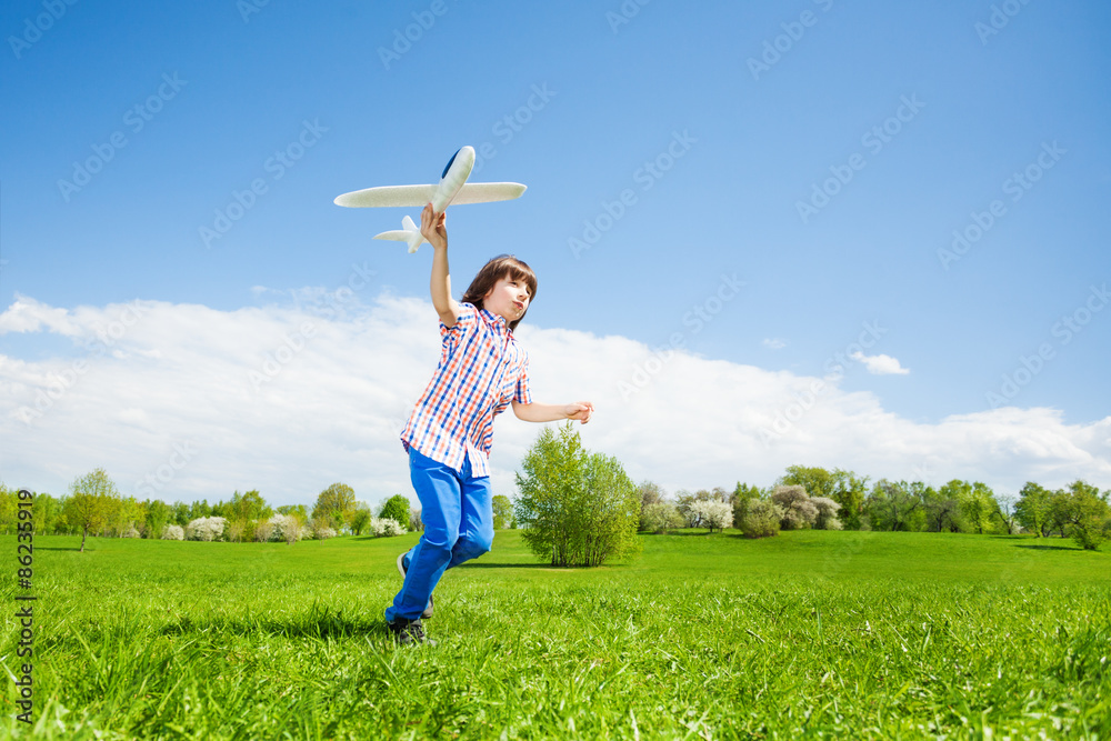 Active boy holding airplane toy during running