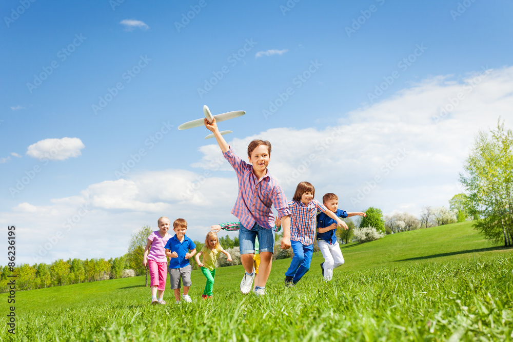 Happy cute boy with plane toy and chasing him kids