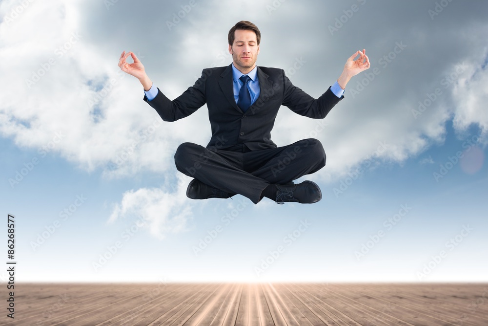 Composite image of calm businessman sitting in lotus pose