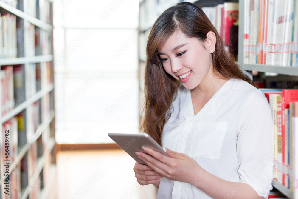 亚洲美女女学生在图书馆使用平板电脑