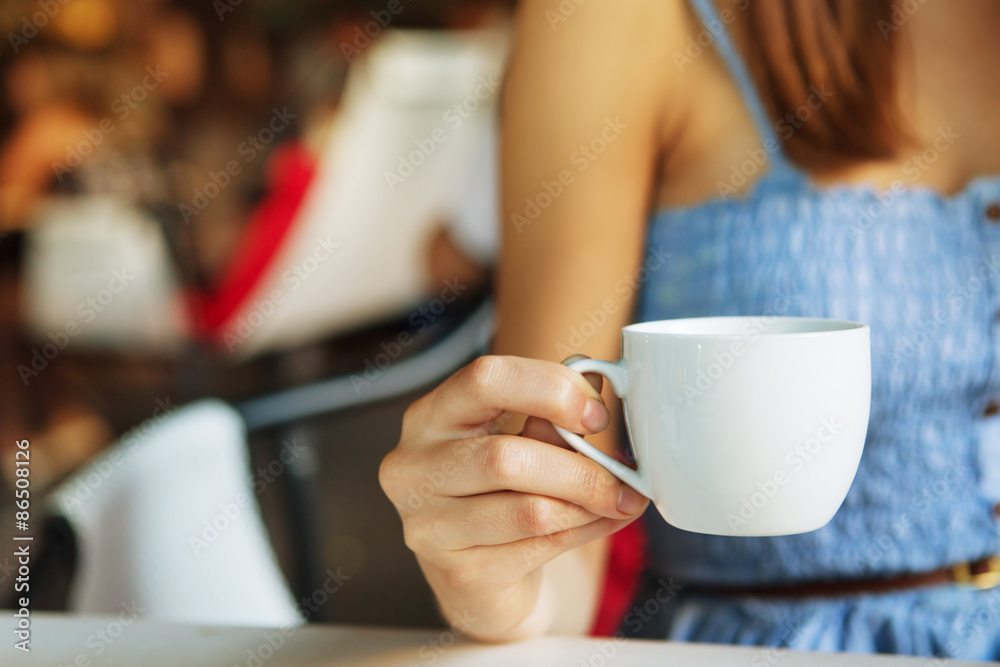 餐厅内部女性手中的一杯茶