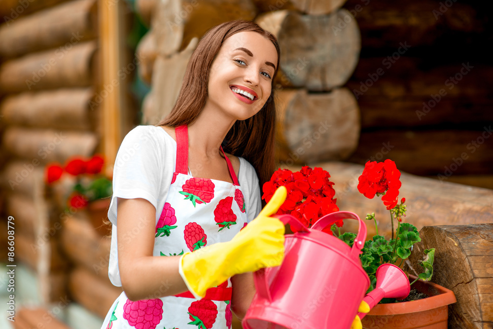 在木屋附近浇花的女人