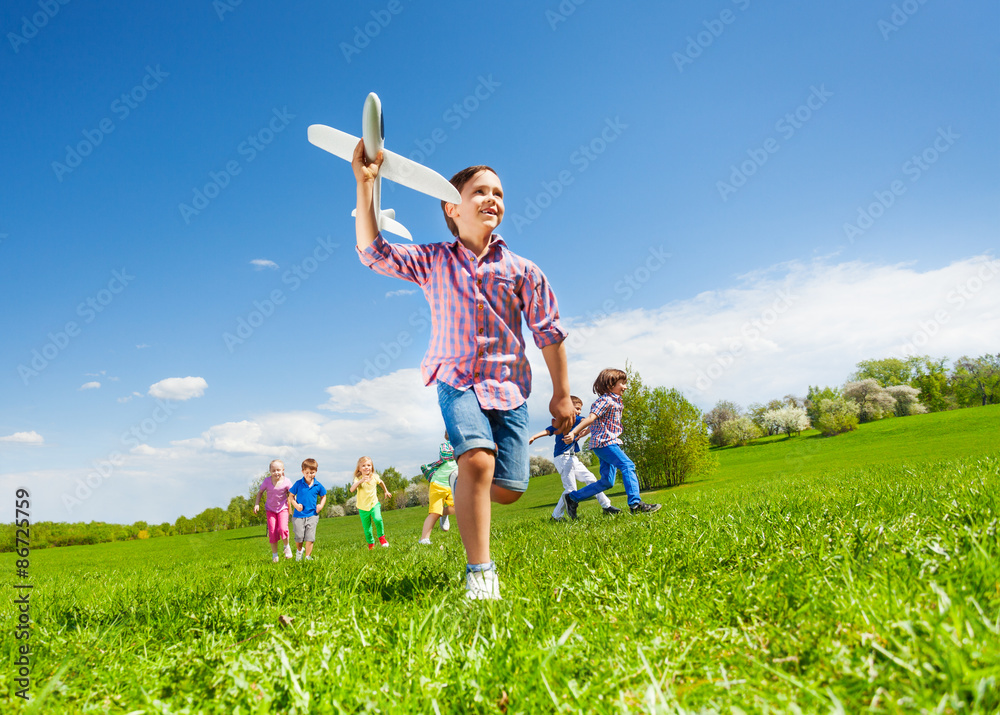 View from below of boy with toy and kids running