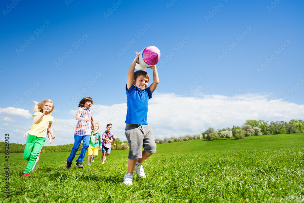 Boy holding rocket carton toy and children running