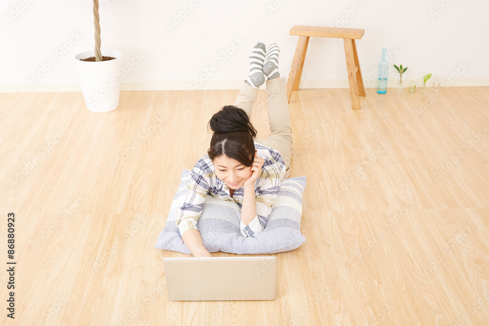 部屋でノートパソコンを使う女性