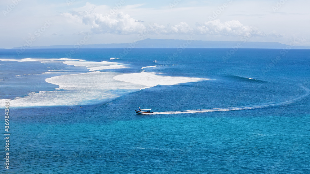 Nusa Dua附近的蓝色海洋鸟瞰图，船和冲浪者在大浪上——娱乐中心