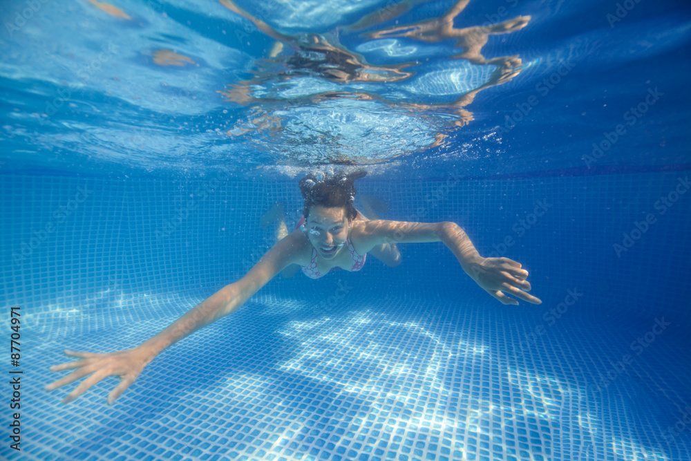 Underwater woman in swimming pool.