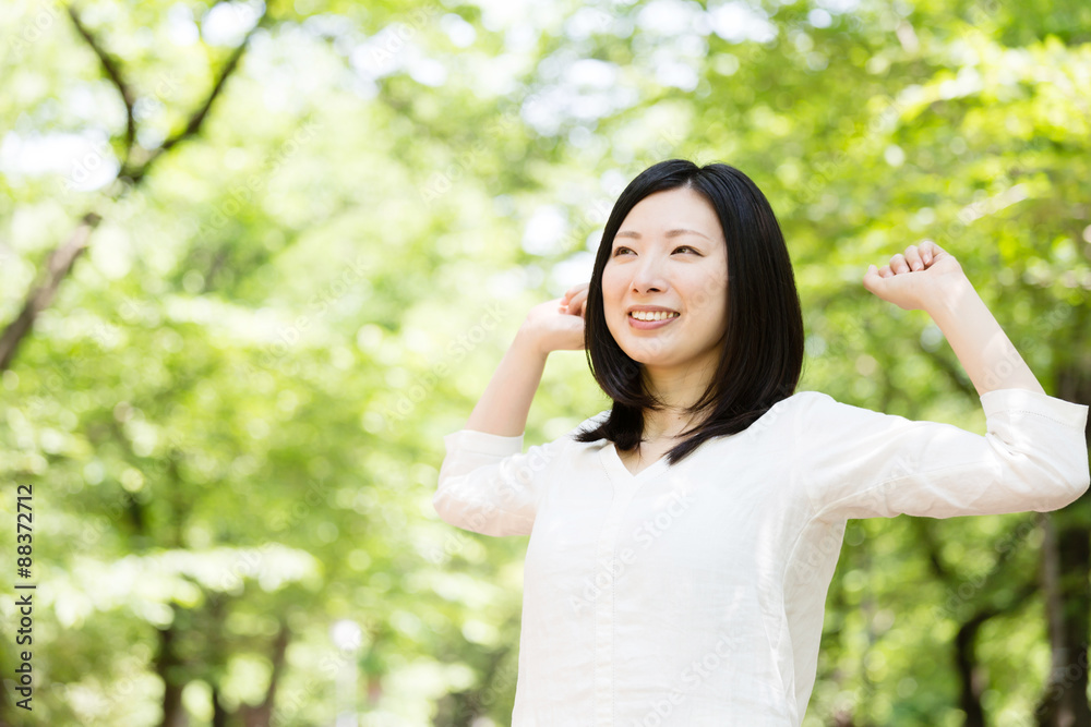 年轻的亚洲女人在公园里放松