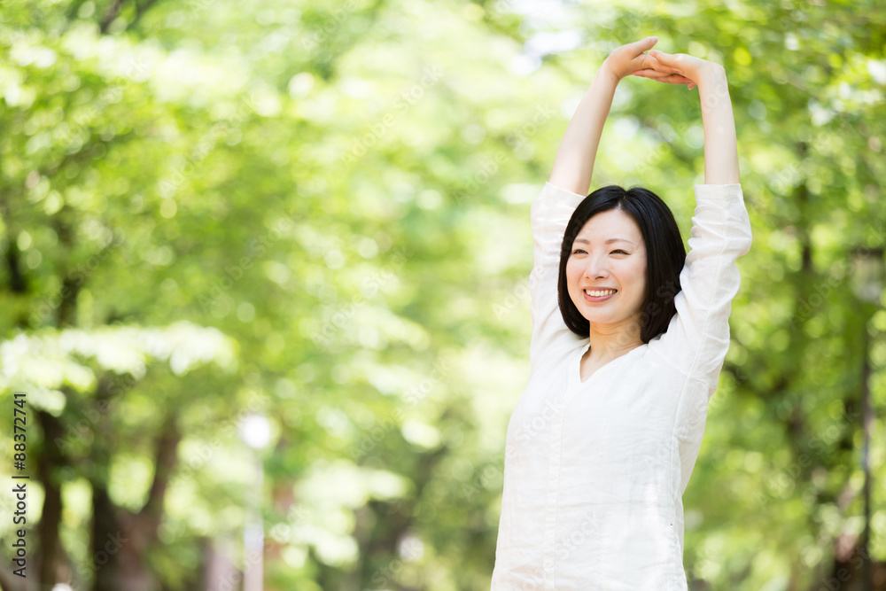 年轻的亚洲女人在公园里放松