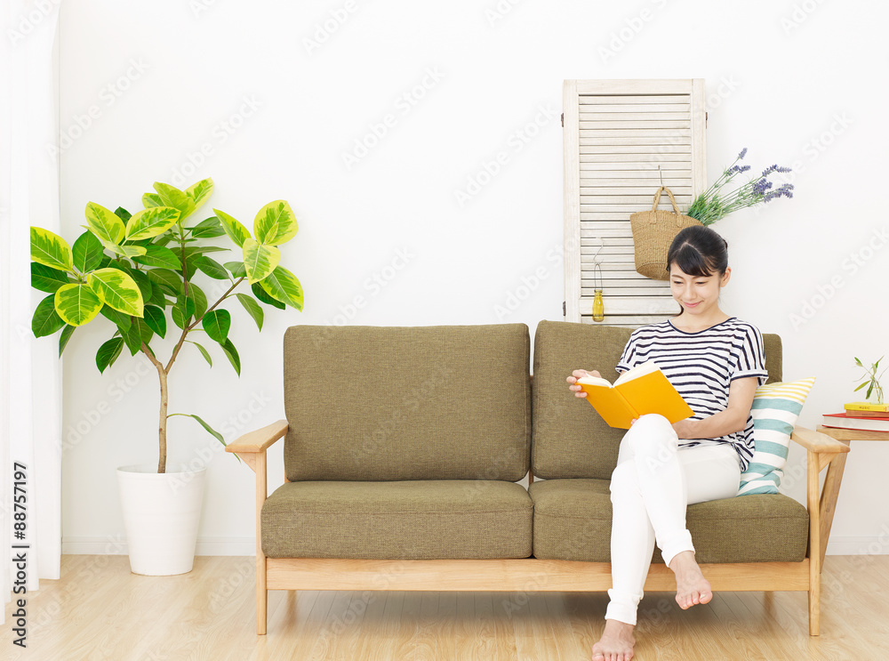 部屋で本を読む女性