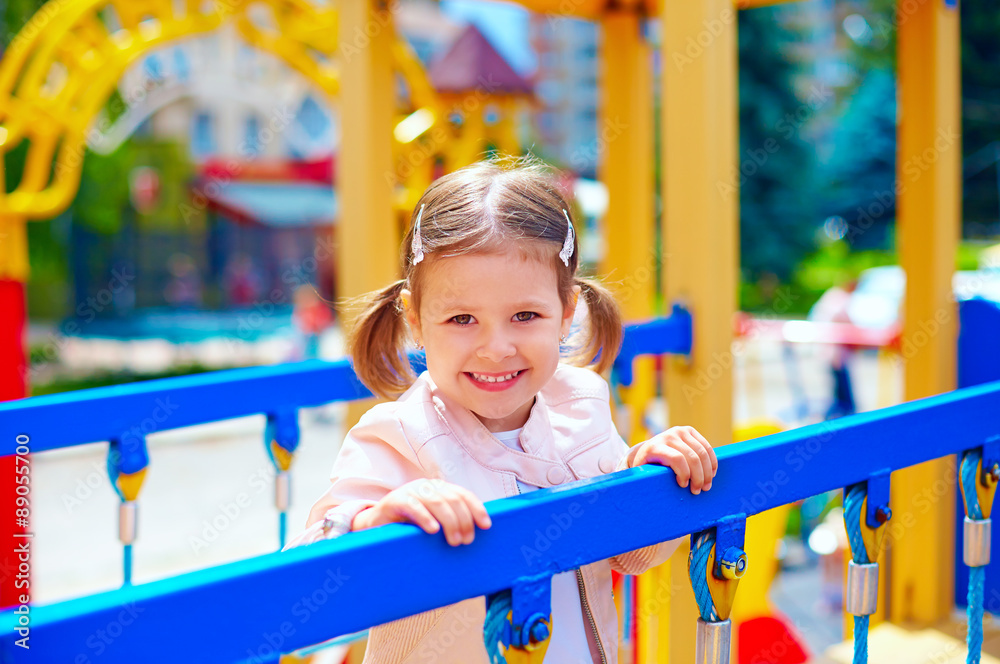 cute smiling girl playing in preschool, on playground