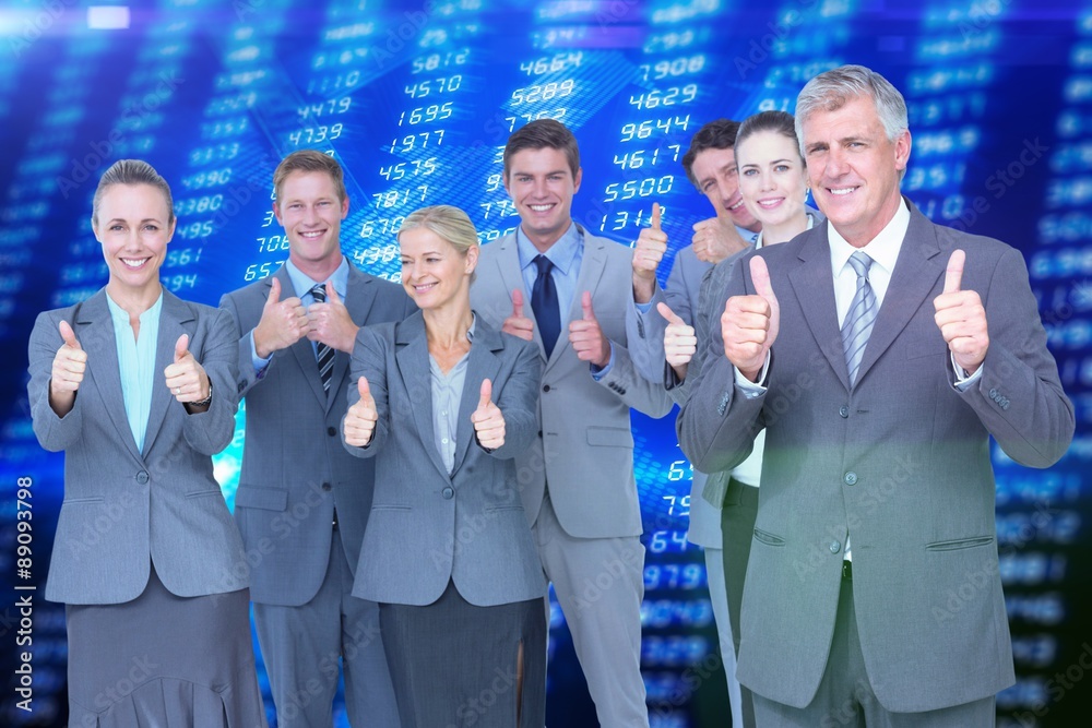 Composite image of smiling business team showing thumbs up