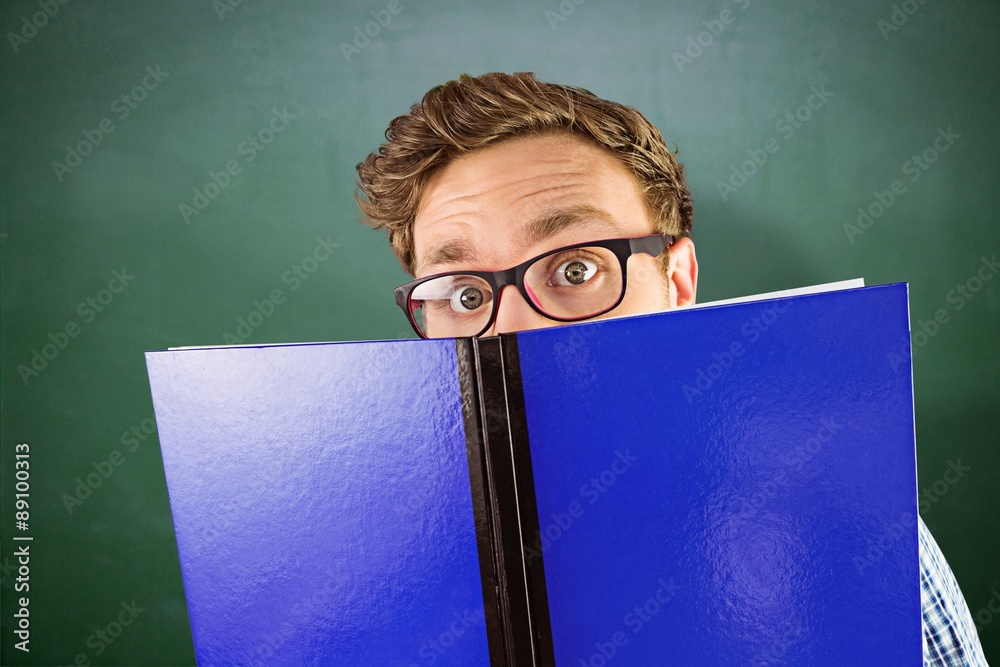 Composite image of geeky student reading a book