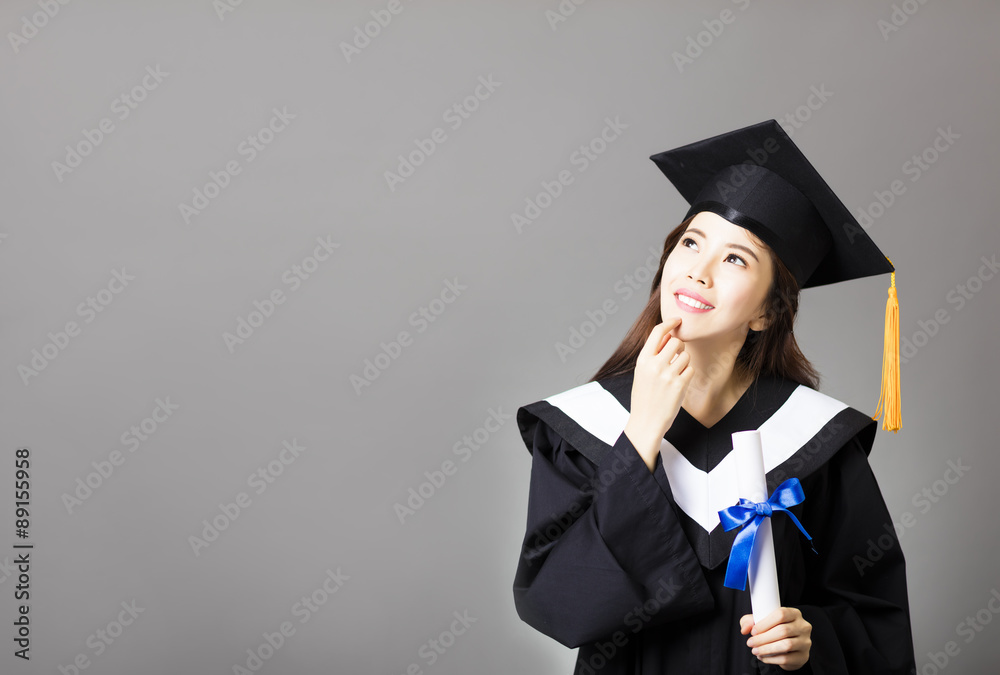 beautiful young  graduate holding diploma and thinking