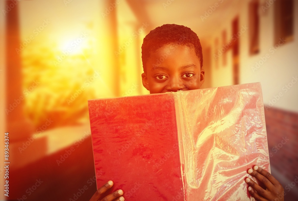 Composite image of cute boy reading book in library