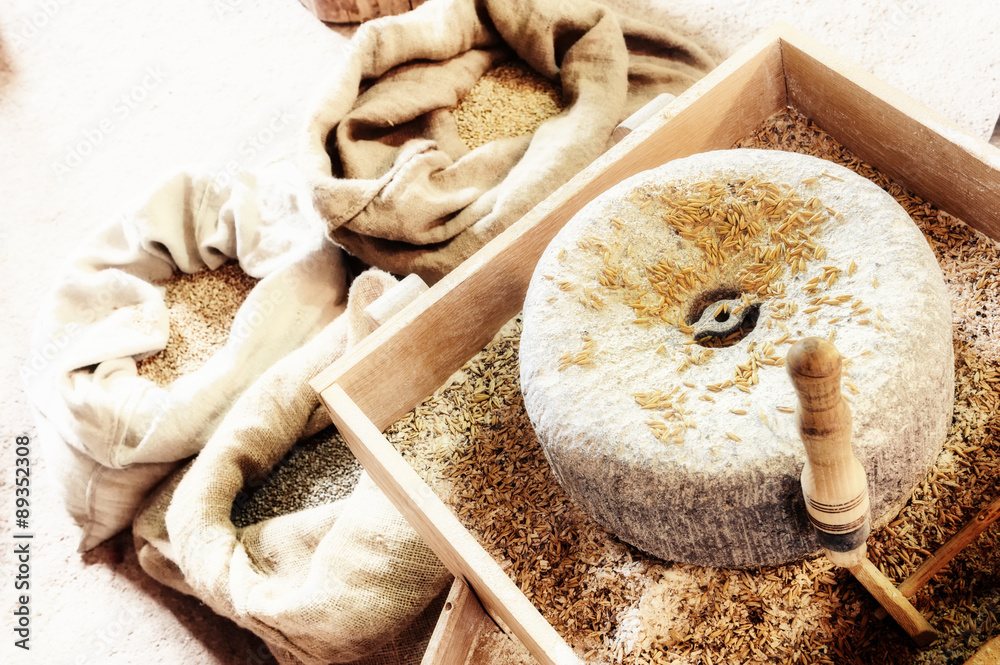 Ancient millstone with wheat grains