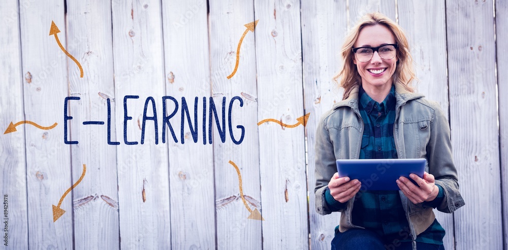 E-learning against smiling blonde in glasses using tablet pc