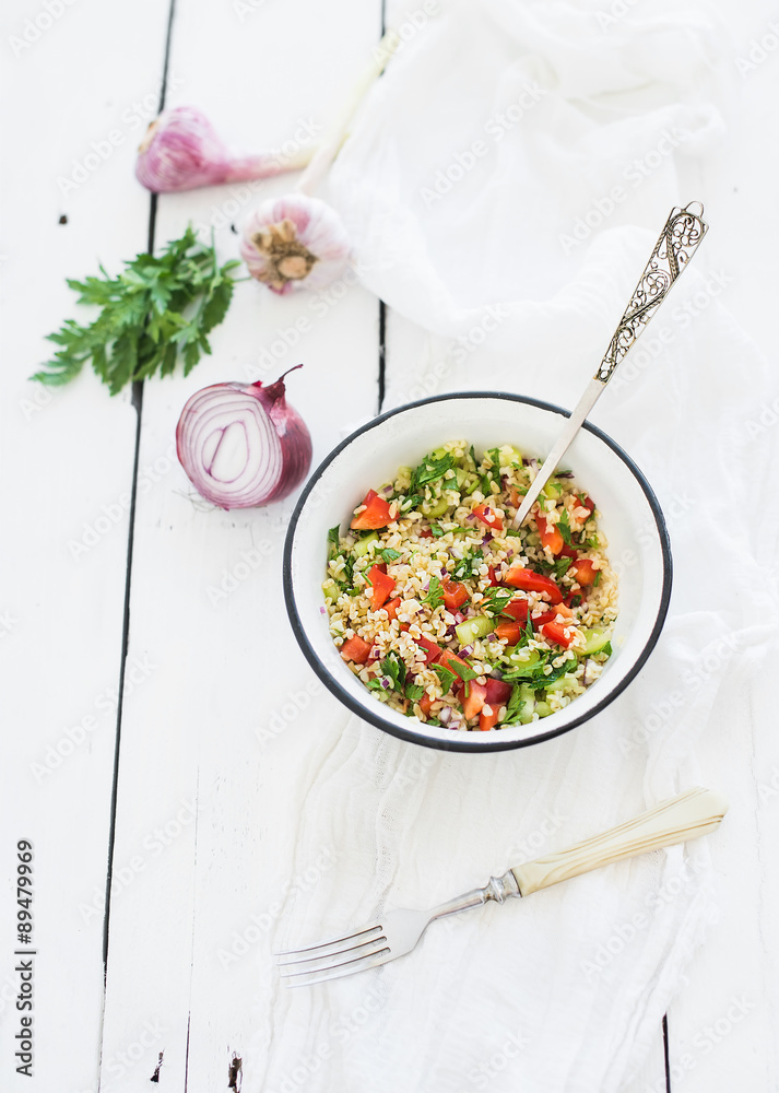 Healthy bulgur salad with paprika, red onion, parsley and garlic