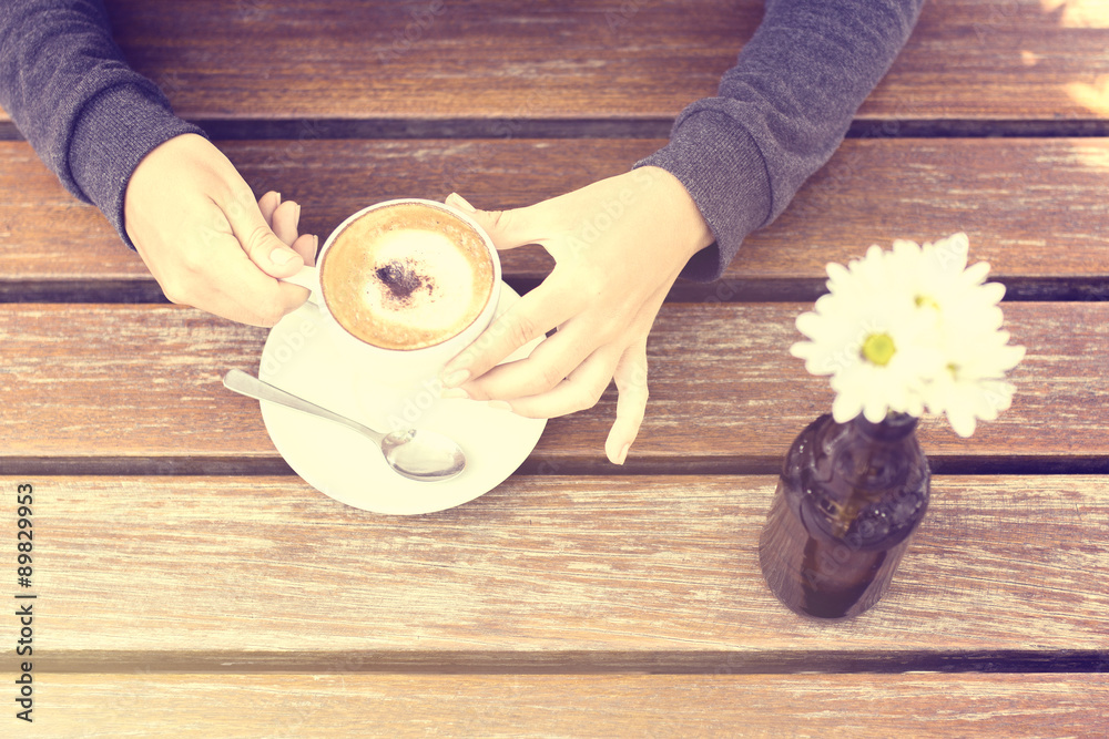 girl with a cup of coffee at the wooden table