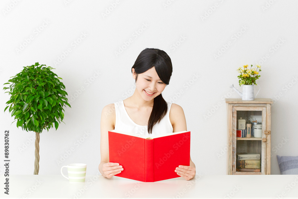 部屋で本を読む女性