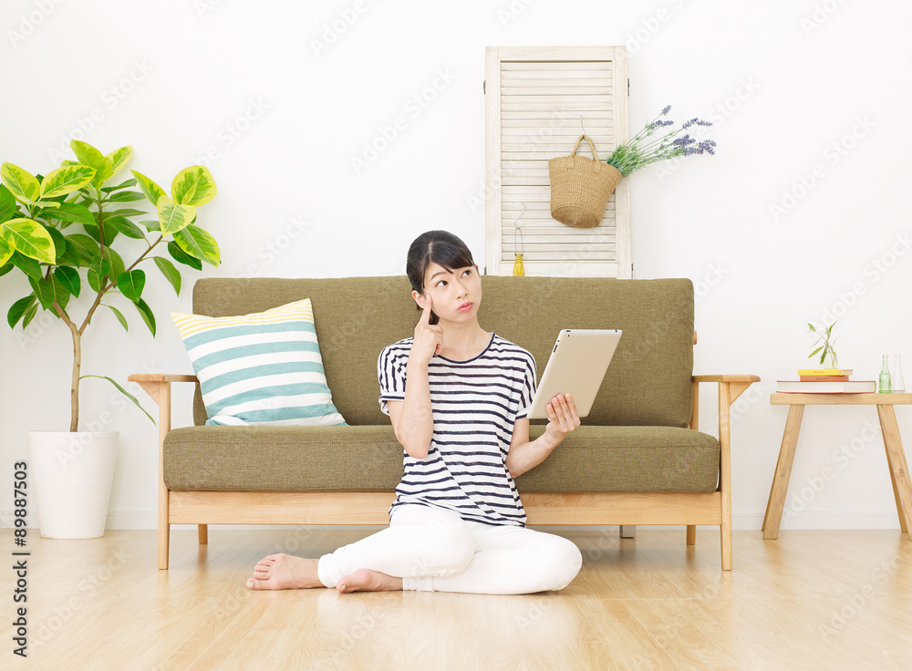 部屋でタブレットを使う女性　考える