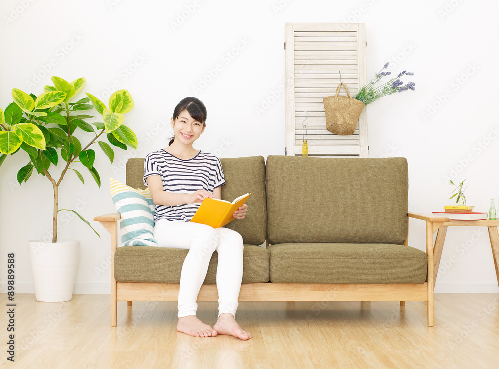 部屋で本を読む女性