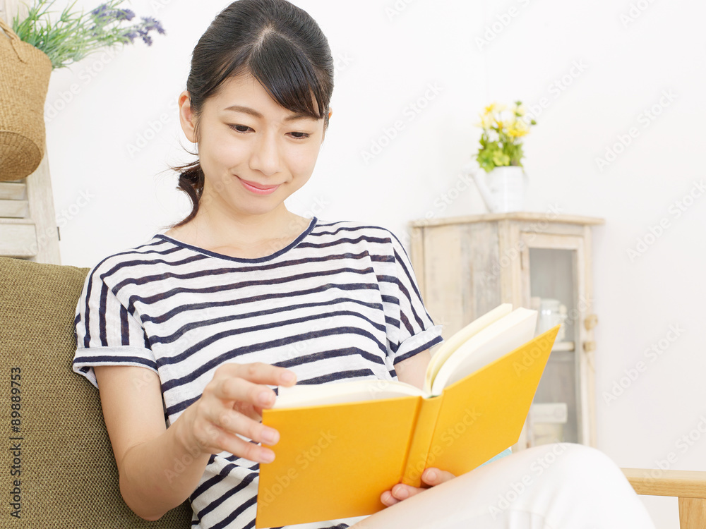 部屋で本を読む女性