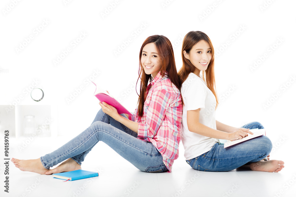 Two  happy teenage students girls study together