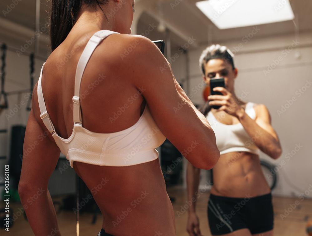 Fitness model taking a selfie in gym