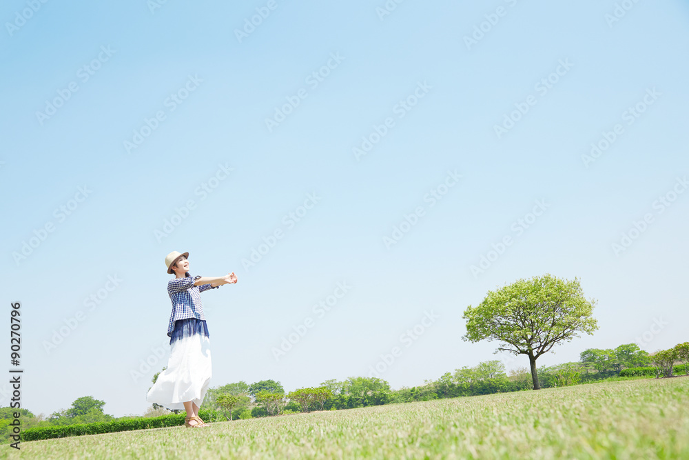 公園に立つ女性　背伸び