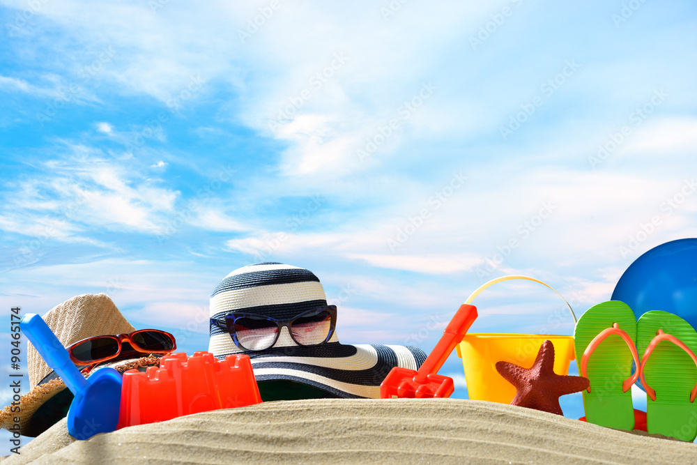 Beach accessories on sandy beach with blue sea and sky background