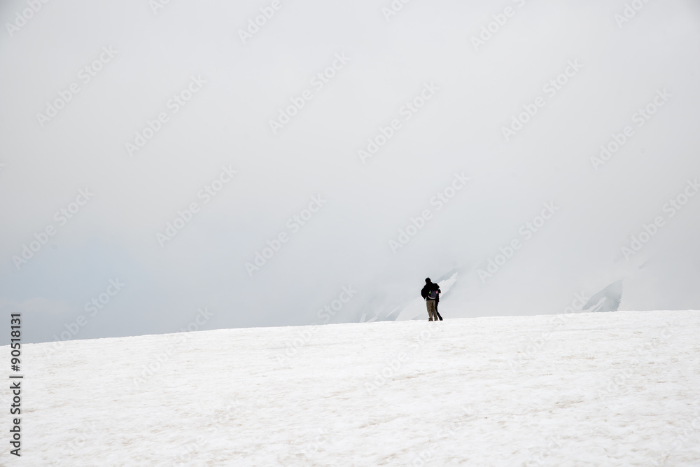 幸福的年轻情侣在雪山之巅放松