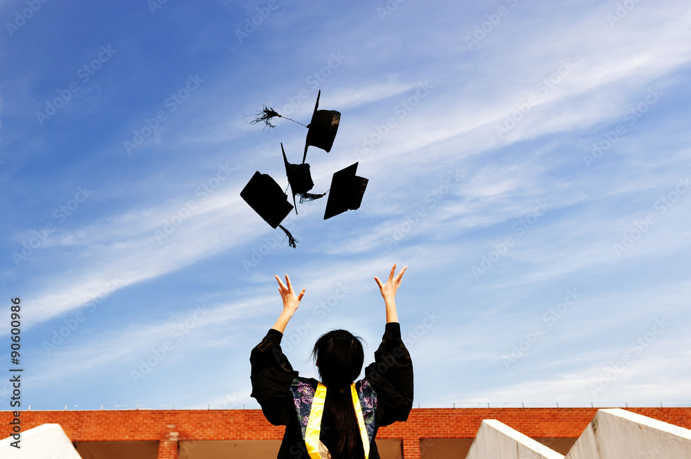 pretty graduate throwing graduation hats in the air.