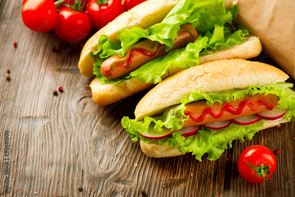 Grilled hot dogs with mustard and ketchup on a wooden table