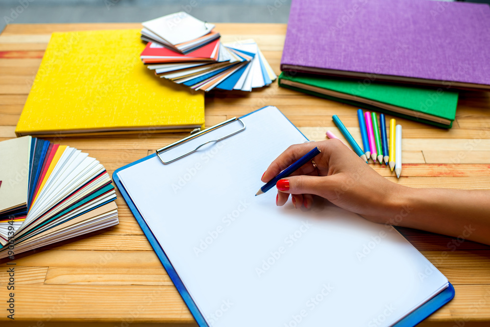 Writing with color pencil on the white sheet of paper