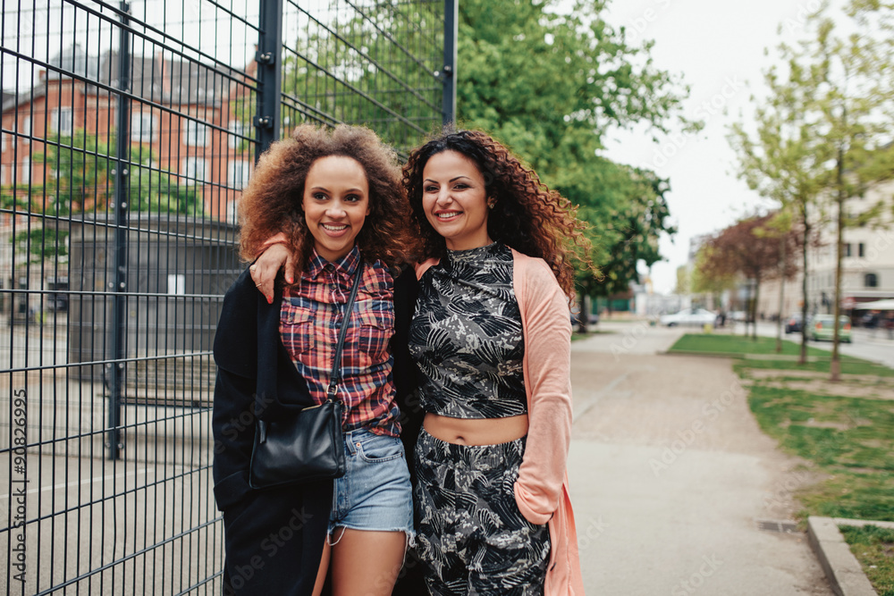 Cheerful young woman walking together on city street