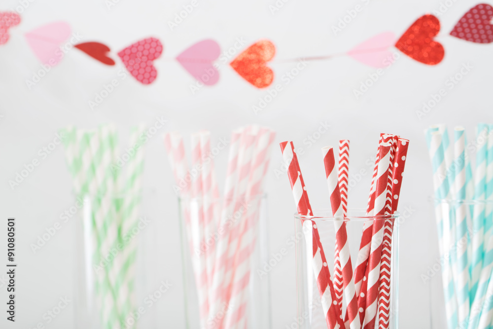 Colorful paper straws with a garland of hearts