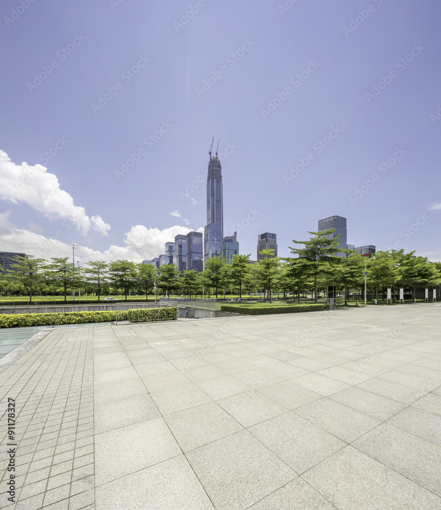 空荡荡的城市广场，有很多植物，附近有一座摩天大楼