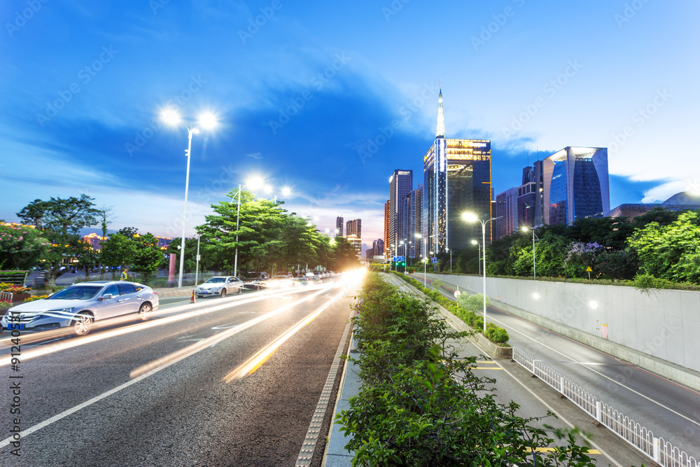 skyscrapers of a modern city at dusk with street lamps