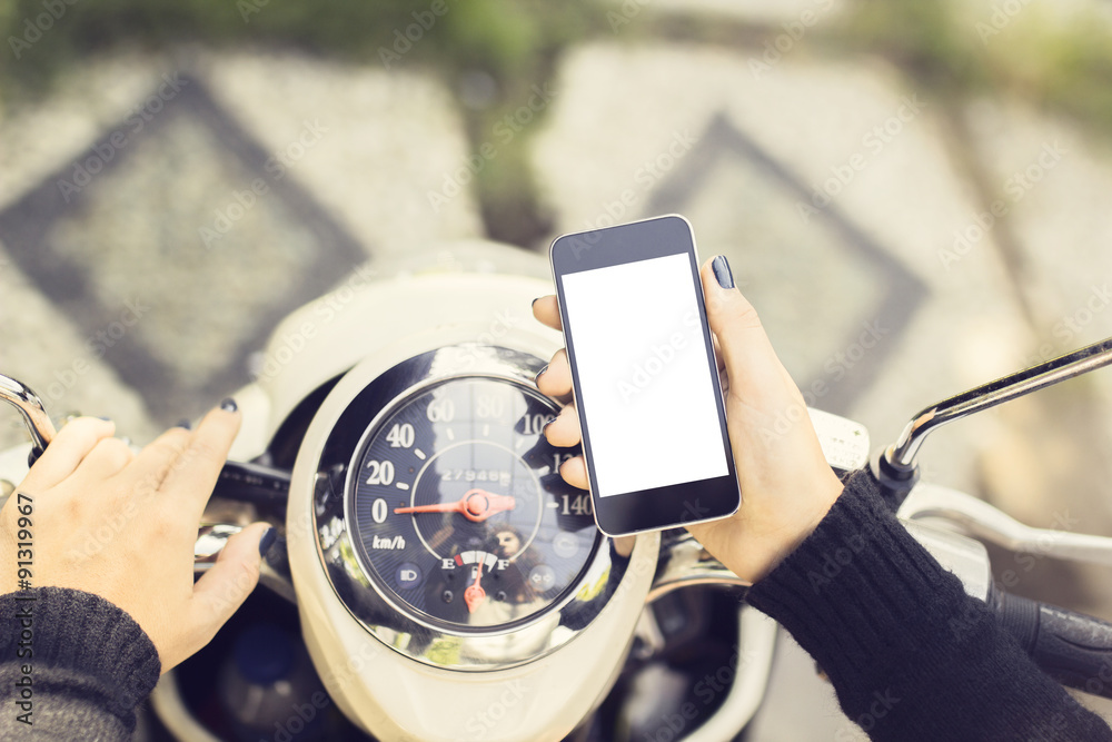 Hipster girl with a blank phone and a motorbike