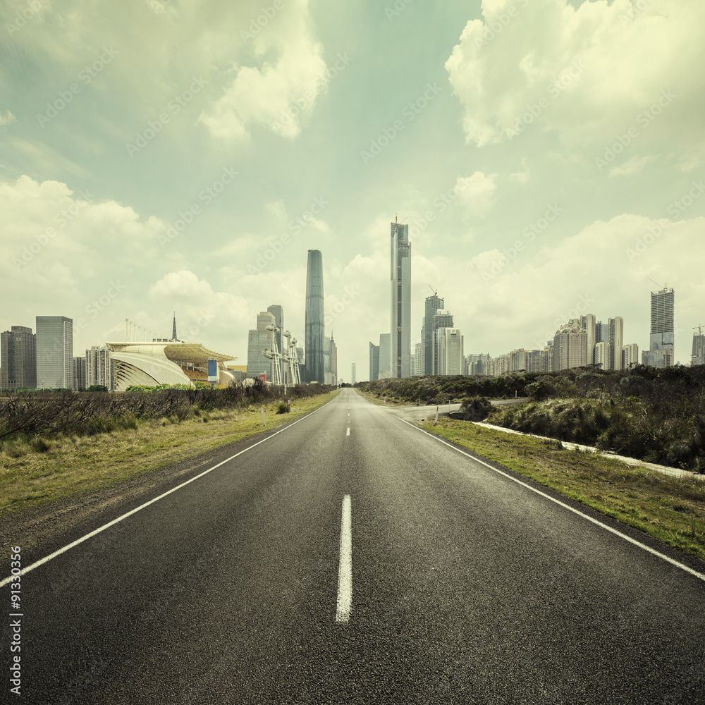 asphalt road and skyscrapers in cloudy day