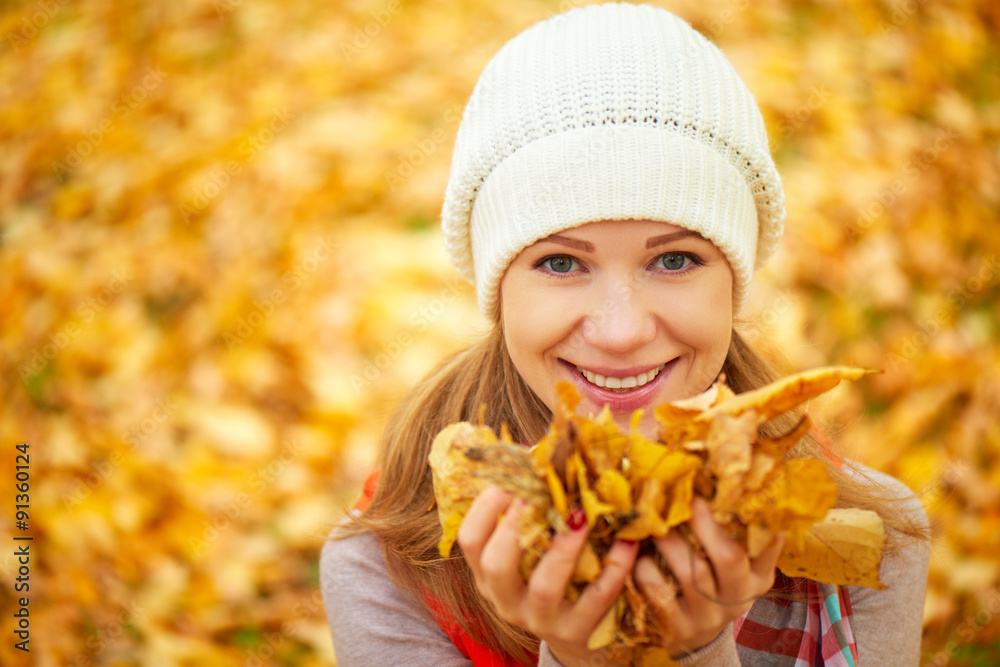 face of happy girl with autumn leaves on walk