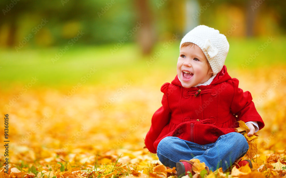 happy child on autumn nature walks in golden foliage