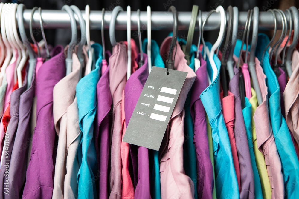 Blank price label on clothes hang on a shelf in a fashion store