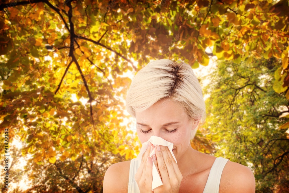 Composite image of sick woman blowing her nose