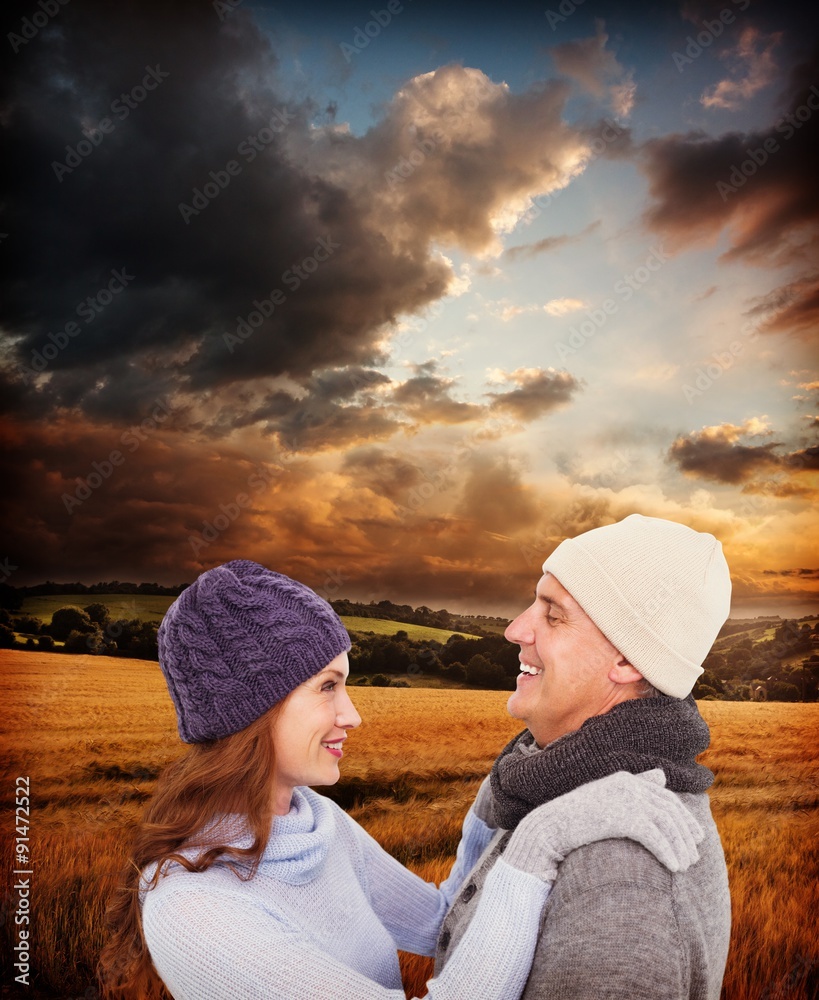 Composite image of happy couple in warm clothing